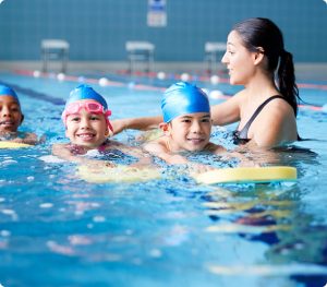 kids learning swimming with a swimming teacher